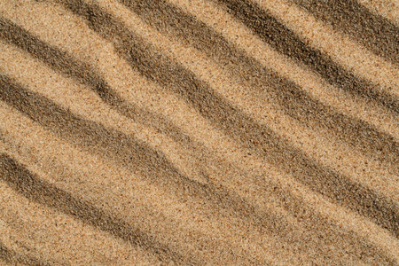background texture of yellow sand with wavy pattern close up