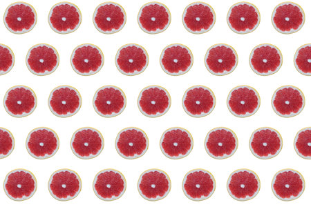 pattern of fresh grapefruit slices on a white isolated background top view