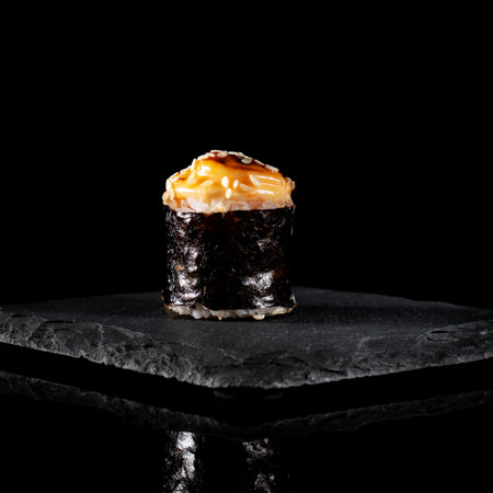 Japanese baked sushi on a graphite stand on a black table with reflectionの写真素材