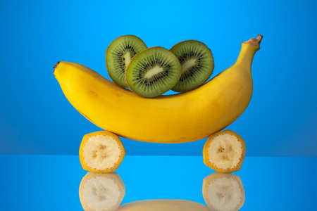 still life banana and kiwi on a blue background close-upの写真素材