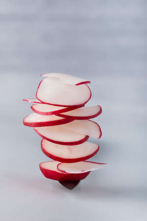 fresh radish cut into thin slices on a light background close-upの写真素材