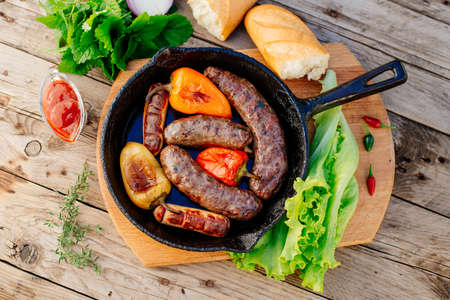 Oktoberfest. Fried lamb sausages and sweet peppers on a cast-iron frying panの写真素材