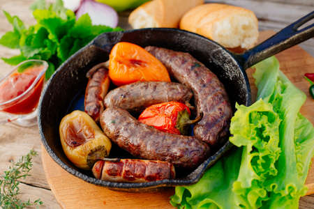 Oktoberfest. Fried lamb sausages and sweet peppers on a cast-iron frying panの写真素材