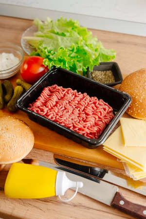 Ingredients for making burgers. Making burgers at home. Ground beef, burger buns, cheese, lettuce. Cooking burgersの写真素材