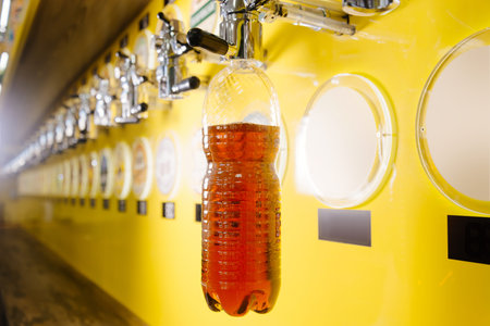Beer is poured into a plastic bottle at a beer shop. Beer dispenser in a beer shop.