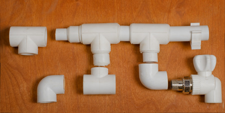 the scheme of a water supply system, heating, from polypropylene products, tees, corners, the crane on a dark wooden background.の写真素材