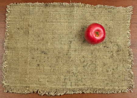 red Apple lying on an old, dirty canvasの写真素材