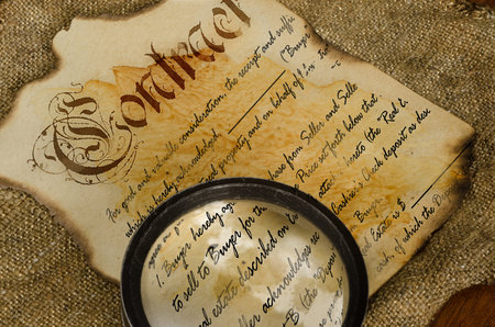 an old contract written on old paper is considered a magnifying glassの写真素材