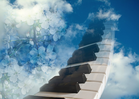 piano keys and flowers of cherry against the blue spring sky.The concept of spring mood.の写真素材