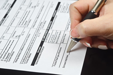 female hand with manicure holds a pen over the banking document