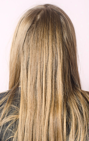 A young girl in a dark t-shirt combing Golden hairの写真素材