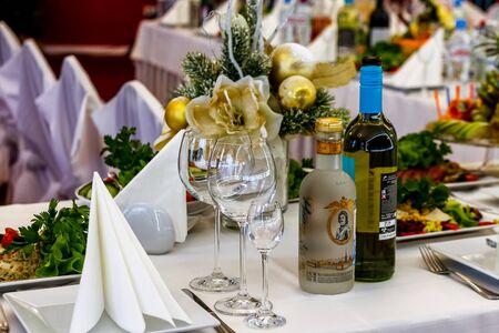 Served dishes to the table for holiday. Cutlery and food on white tablecloths in the restaurant. Design a festive Banquet. Luxurious food for guests and visitors.のeditorial素材