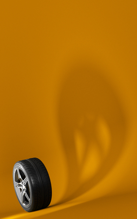 Car wheel isolated on orange background. Tyre. Poster booklet cover design. Ghost shadow. 3d illustrationの写真素材