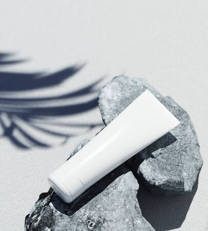 Natural Cosmetic product presentation template. Grey stones and palm leaf shadow blanc cosmetic jar. White bbackground. 3d illustration content.の写真素材