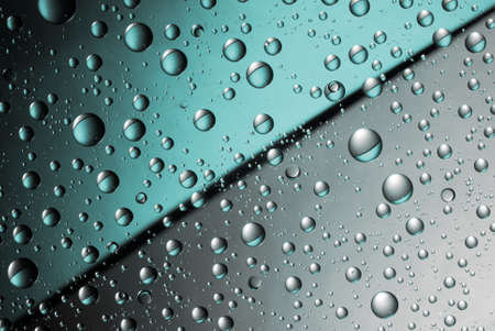 Abstract split background with water drops on the glass. Blue and silver. Close up.の写真素材