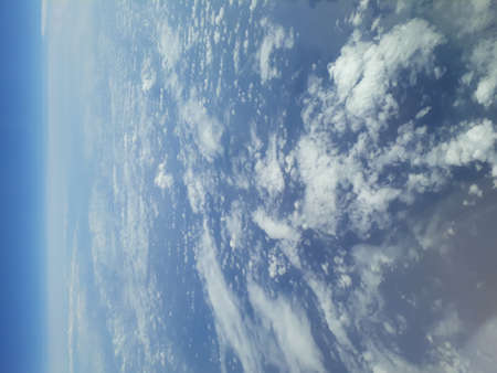 Looking down on the clouds and the horizon from the planeの写真素材