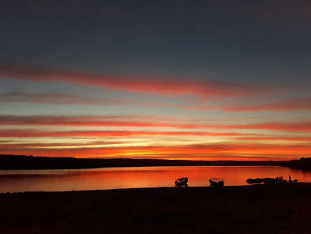 The evening sky by the dam with red and blue interspersed. There is a mountain behind.の写真素材