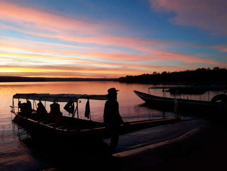 The evening sky by the dam with red and blue interspersed. There is a mountain behind.の写真素材
