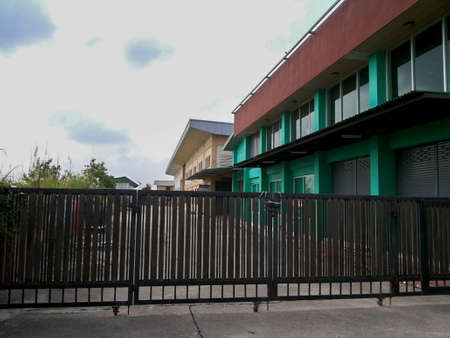 black fence in front of green and cream buildingの写真素材
