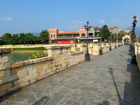 Bridge over a canal made of stone. There are lamp posts on the bridge as well.の写真素材