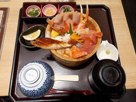 Raw fish bowl with salmon, tuna, crab, shrimp, eel, sweet egg, sea urchin, and soup.の写真素材