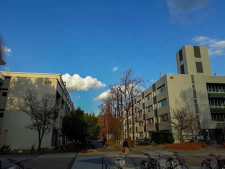 view of the university building in autumn. There is a bicycle parked in front, clear sky, beautiful clouds.の写真素材