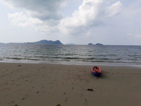 Rowing boat on a mountain beach behind cloudy skyの写真素材