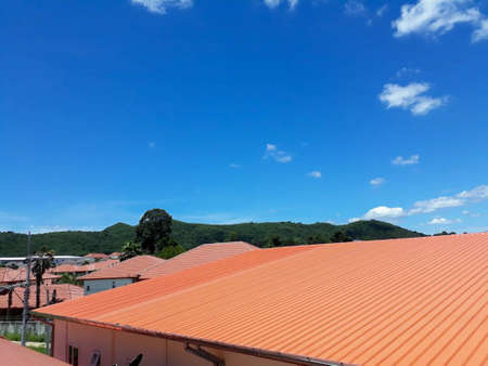 Orange house roof on a clear day. There is a mountain in the backgroundの写真素材