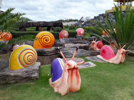 A garden filled with multicolored sculptures of snails, shells and palm trees.の写真素材