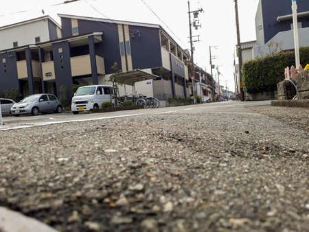 A concrete street view looking up at blue-yellow houses.の写真素材