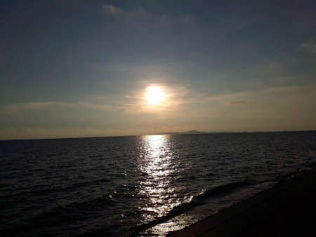 The sun is about to set over the sea on a clear day.の写真素材