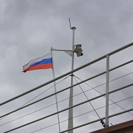 Russian tricolor flag on mast of the ship onagainst the gray sky .の写真素材