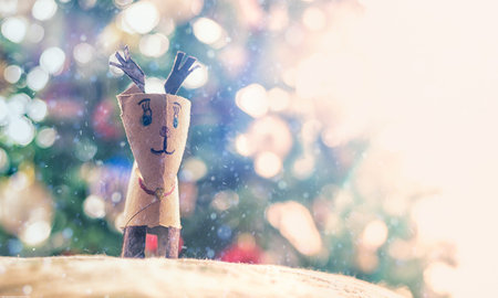 Hand made reindeer of a used toilet paper roll faces a snowstorm.