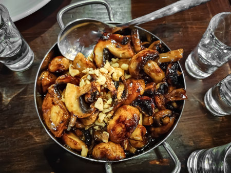 Grilled champignon mushrooms in a metal pan with shallow depth of field. Food photo.