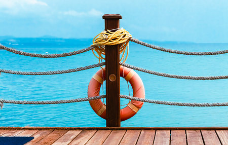 Orange lifebuoy on the beach. Safety on the water, lifebuoy on a wooden pier. Water rescue.の写真素材