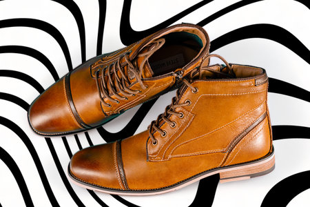 A pair of premium calfskin boots on a black and white background. horizontal shot. Men's shoe ideas.