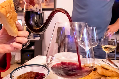 A sommelier pours red wine from a decanter to reveal its flavor and aroma.の写真素材
