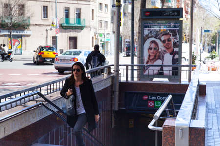 Barcelona, Spain - 9 April 2015: A young woman wearing sun glasses going out of metro station Les Cortsのeditorial素材