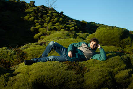 Route 1, Iceland - 4 November 2016: Sole tourist enjoying moss bed in Icelandのeditorial素材