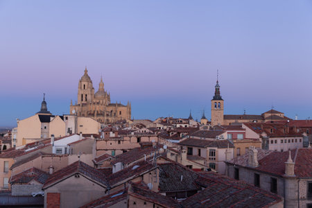 Segovia, Spain - 4 January 2022: Panoramic view of Segovia with the towers of cathedral at sunset with purple sky in winter with Guadarrama Mountains in the backgroundのeditorial素材