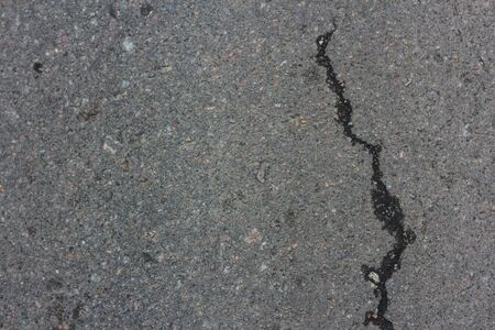 Gray asphalt cracked.Macro closeup on concrete asphalt cracks on the roadのeditorial素材
