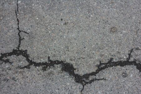 Gray asphalt cracked.Macro closeup on concrete asphalt cracks on the roadのeditorial素材