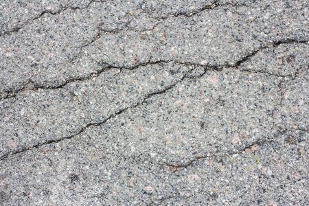 Gray asphalt cracked.Macro closeup on concrete asphalt cracks on the roadのeditorial素材
