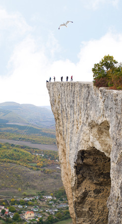People on a steep high rockの写真素材