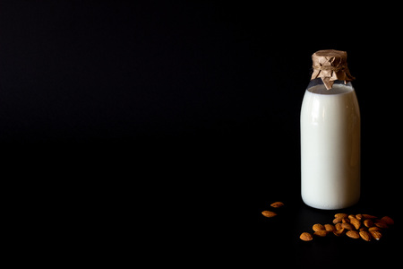 Milk and almonds on a black background.の写真素材