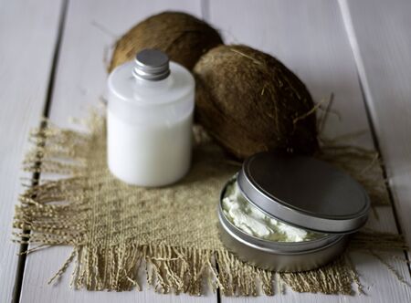 Coconuts and coconut oil in a metal pot. Wooden backgroundの写真素材