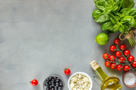 Vegetables on a concrete background. Italian cuisine. Tomatoes, basil, olives cheese