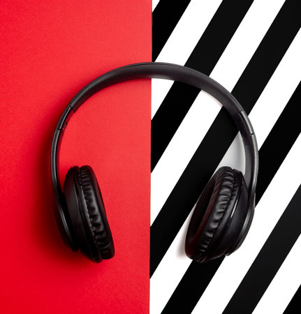 Black headphones on a red background. Minimal concept. Flat lay. Mock-up. Music.の写真素材