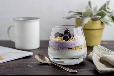 Yogurt with granola, chia seeds and blackberries on a wooden background. Dessert. Breakfast. Healthy eating. Vegetarian food. Recipe.の写真素材
