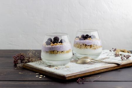 Yogurt with granola, chia seeds and blackberries on a wooden background. Dessert. Breakfast. Healthy eating. Vegetarian food. Recipe.の写真素材